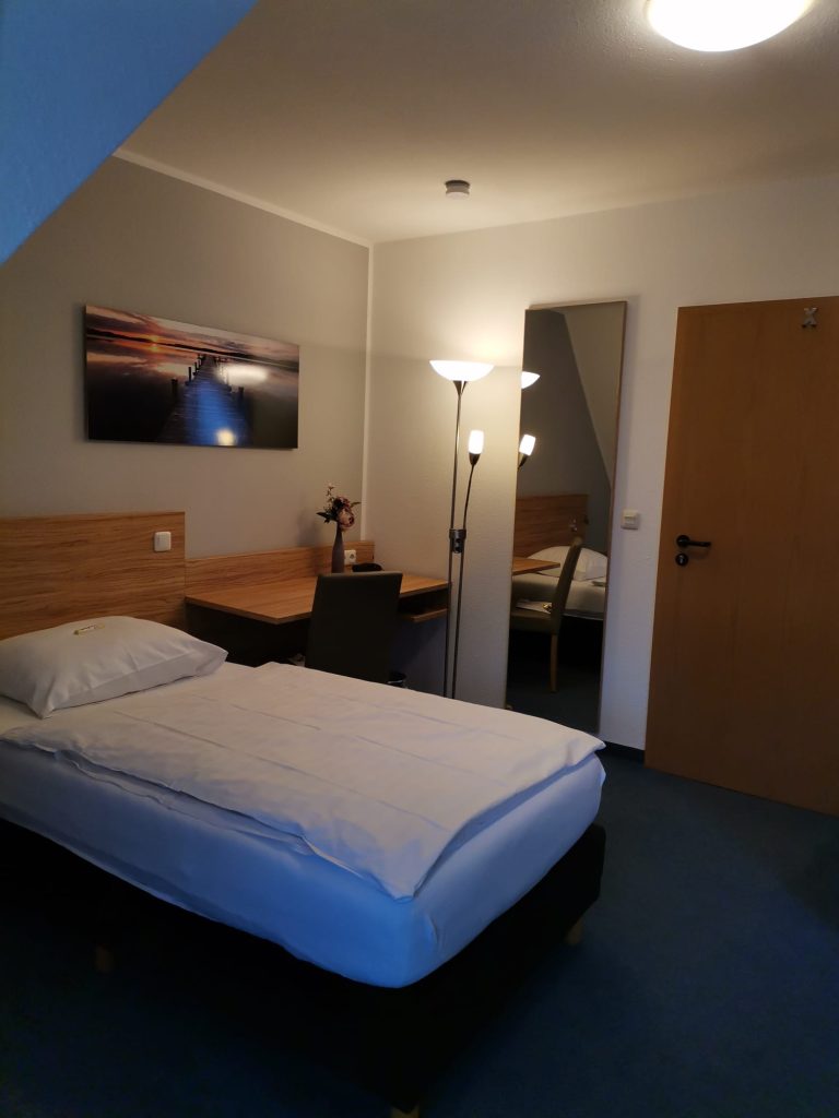 Schlafzimmer mit Bett und Schreibtisch, Landhaus Hotel Müller